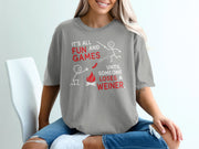 Gray t-shirt with "It's All Fun and Games Until Someone Loses A Weiner" text and stick figures.