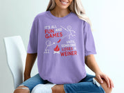 Lavender t-shirt with red and white text and stick figure graphics about fun and games.